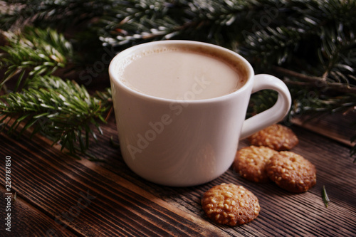 Coffee, hot chocolate or cocoa with cinnamon stick in a cup and fir branches. Winter hot drink for cold weather. New year and Christmas concept