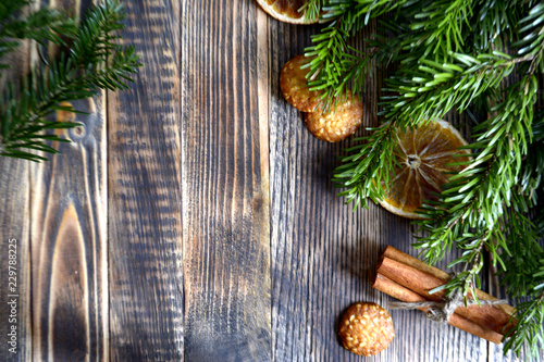 Christmas and new year background frame or postcard Christmas composition with fir branches dried oranges cookies cinnamon sticks and a scarf on a wooden background