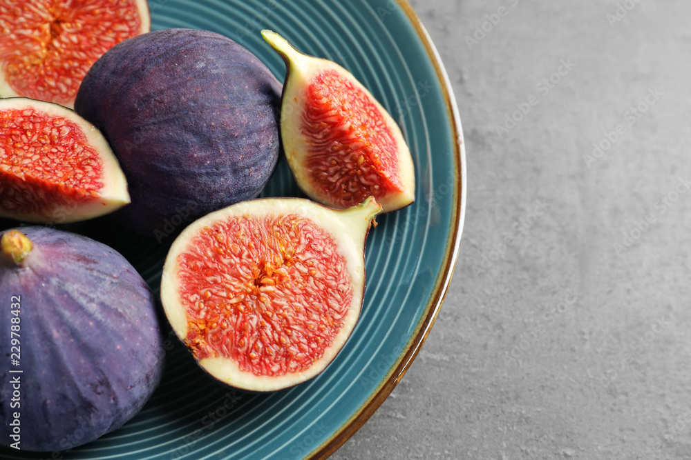 Plate with fresh ripe figs on gray background, top view Plate with fresh ripe figs on gray background, top view
