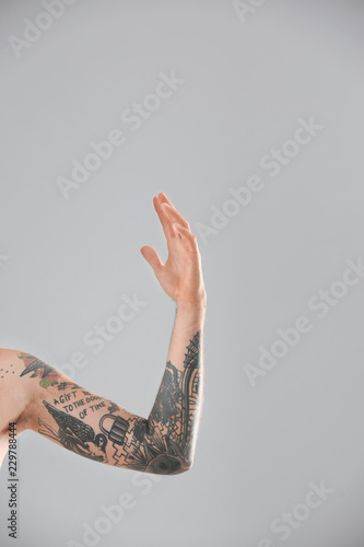 Man s arm with stylish tattoos on grey background