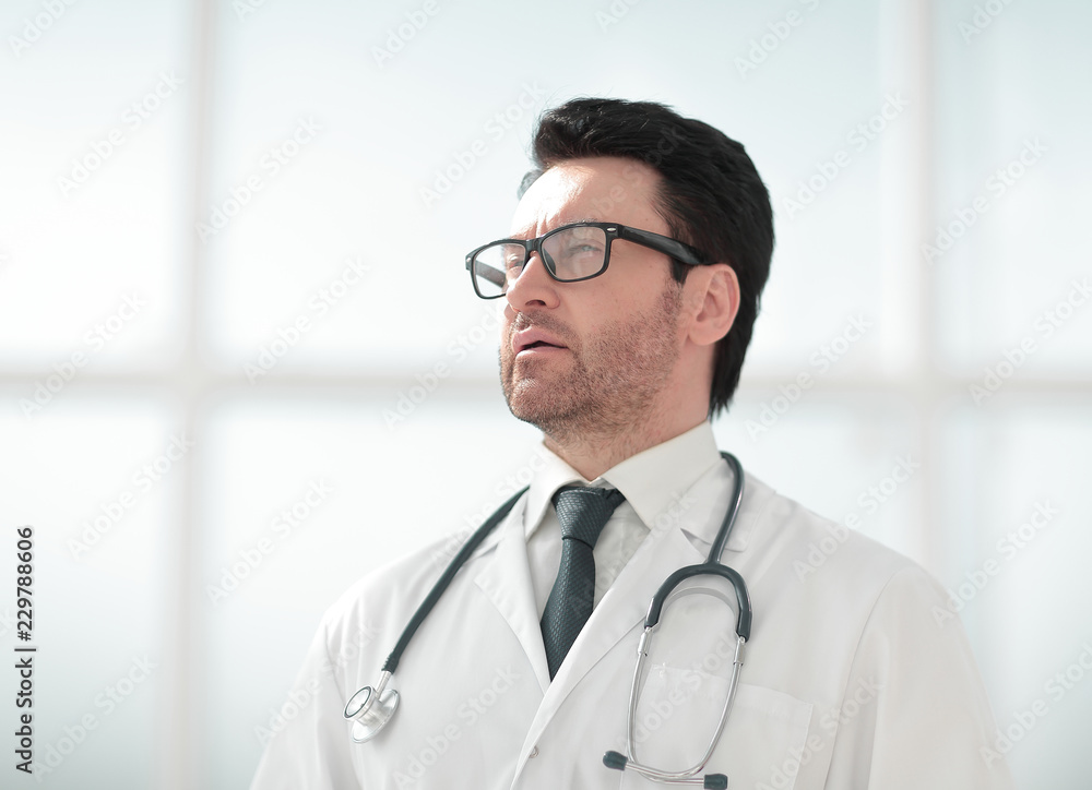 serious doctor on the background of a bright room serious doctor on the background of a bright room