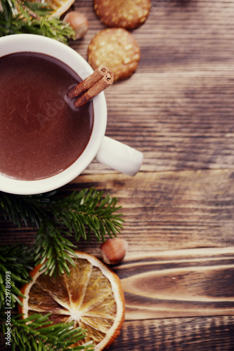 Hot chocolate or cocoa with cinnamon stick in a cup and fir branches. Winter hot drink for cold weather. New year and Christmas concept Top view