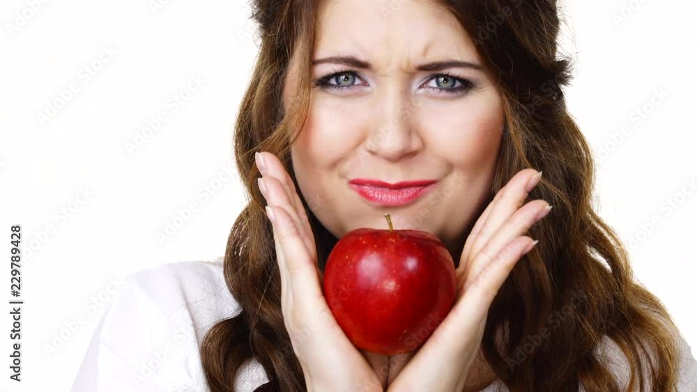 Woman toothy smile brunette female holding red apple fruit in hand close to face, isolated on white. Healthy eating, vegetarian food, diet concept Woman toothy smile brunette female holding red apple fruit in hand close to face, isolated on white. Healthy eating, vegetarian food, diet concept