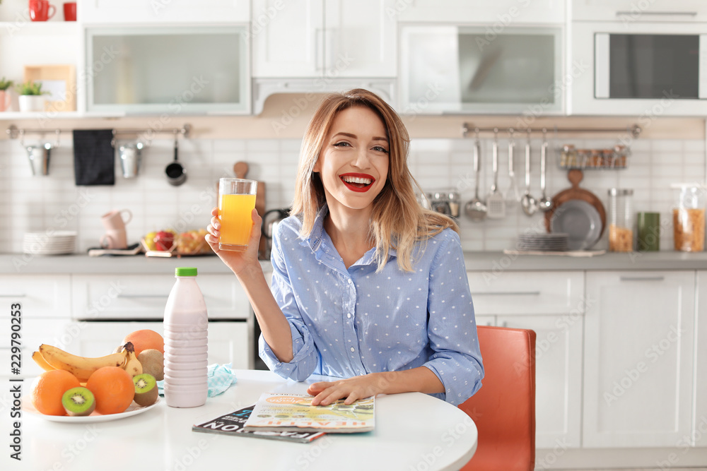 Portrait of food blogger with glass of juice in kitchen