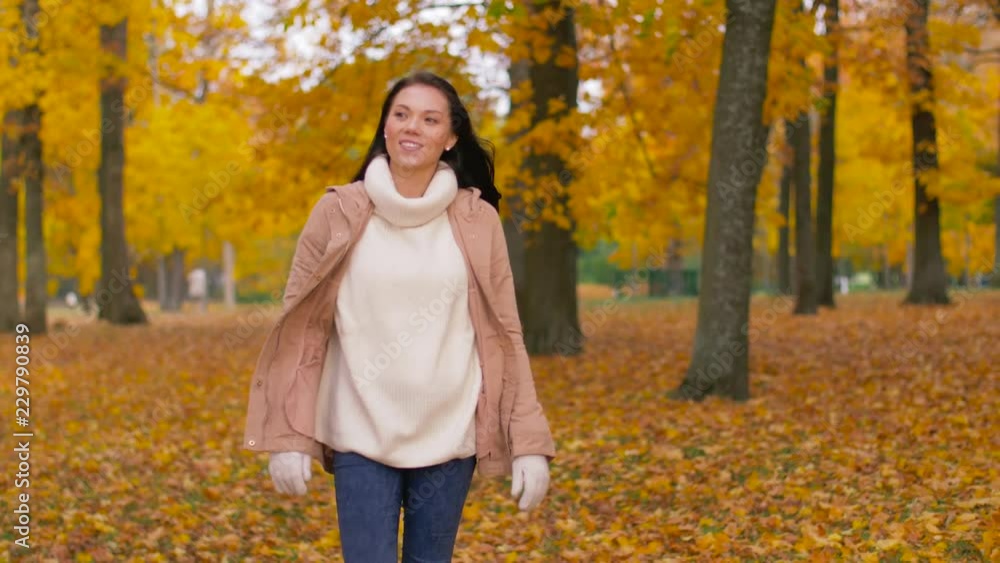 season and people concept - happy young woman walking in autumn park season and people concept - happy young woman walking in autumn park