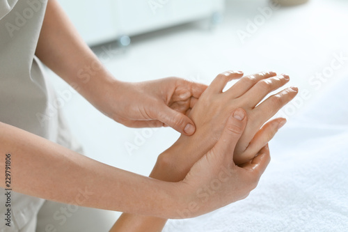 Woman receiving hand massage in wellness center, closeup
