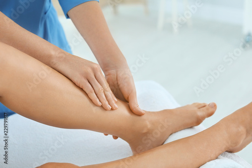 Woman receiving leg massage in wellness center, closeup