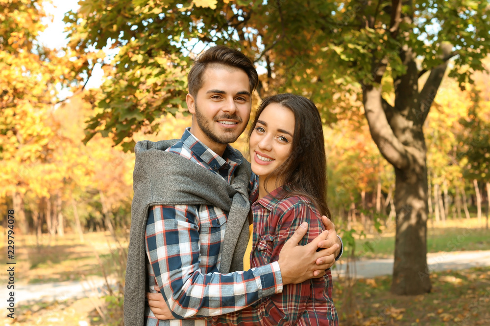 Young lovely couple spending time together in park. Autumn walk