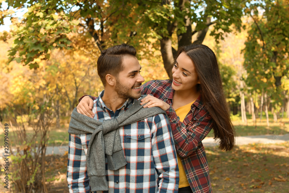 Young lovely couple spending time together in park. Autumn walk Young lovely couple spending time together in park. Autumn walk