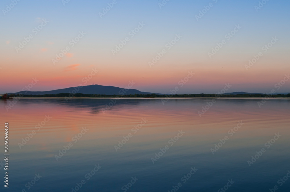 Reflection of Sleza Mountain in Mietkow Lake at sunset in Lower Silesia, Poland