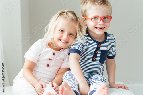 Smiling brother and sister sitting together photo