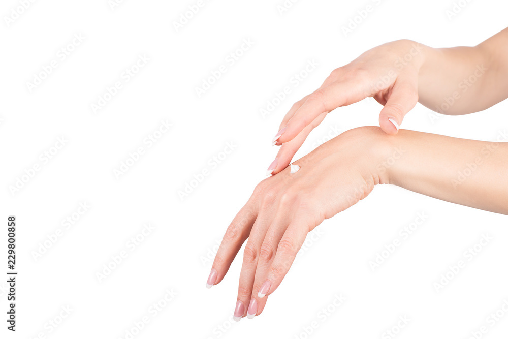 Female hands applying hand cream, white background, closeup