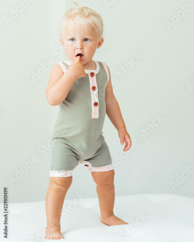 Standing toddler with a finger in her mouth