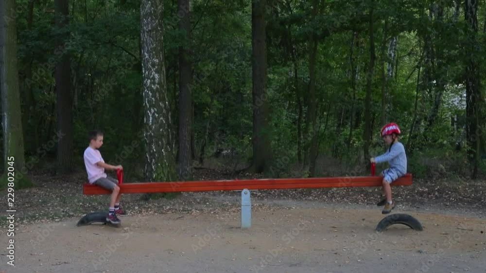 two boys ride on a swing balance two boys ride on a swing balance