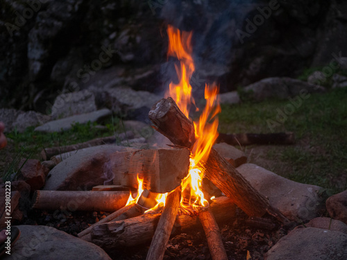 Logs of an improvised campfire burning bright against the darkness of the night