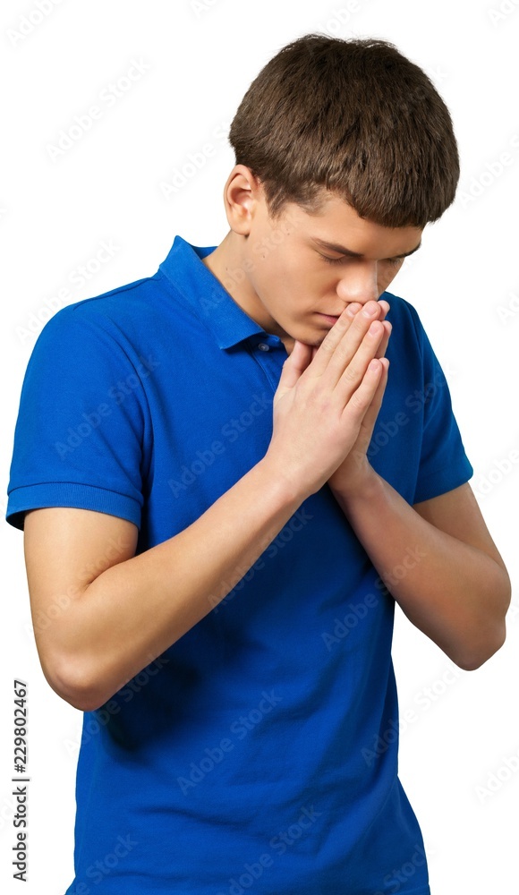 Young man standing and praying Young man standing and praying