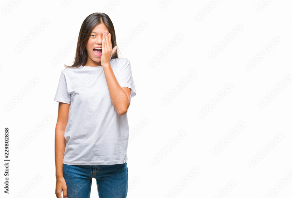 Young asian woman over isolated background covering one eye with hand with confident smile on face and surprise emotion. Young asian woman over isolated background covering one eye with hand with confident smile on face and surprise emotion.