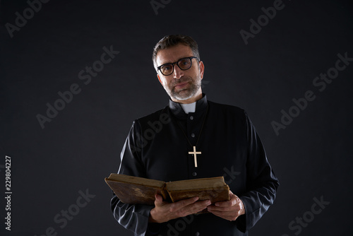 Priest portrait with Holy Bible in hands photo