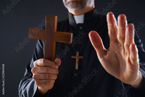 Carta da parati Priest holding cross of wood praying