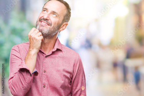 Middle age hoary senior man over isolated background with hand on chin thinking about question, pensive expression. Smiling with thoughtful face. Doubt concept.