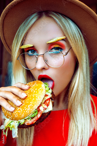 Stylish young lady in red with burger