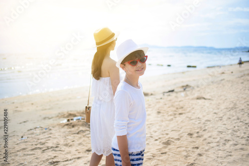  happy family mother with boy walks holding hand on the beach ,white sand beach  ,look happy in the summer