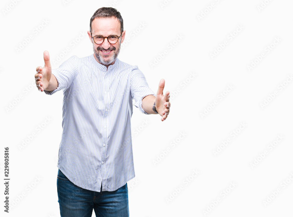 Middle age hoary senior man wearing glasses over isolated background looking at the camera smiling with open arms for hug. Cheerful expression embracing happiness. Middle age hoary senior man wearing glasses over isolated background looking at the camera smiling with open arms for hug. Cheerful expression embracing happiness.