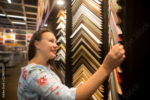 Beautiful young caucasian woman choosing the right item for her apartment in a modern home decor © Khaligo