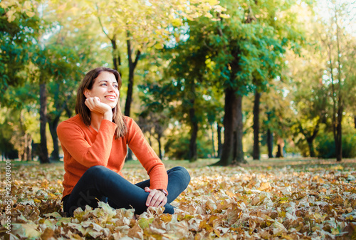 Yound brunette woman enjoying fall in the park