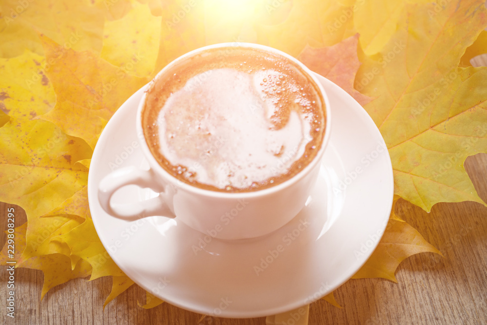 Autumn leaves and coffee cup over wood background with copy space Autumn leaves and coffee cup over wood background with copy space