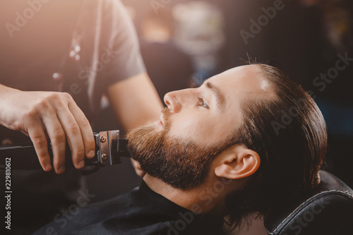 Man hipster having barber shave the barbershop.