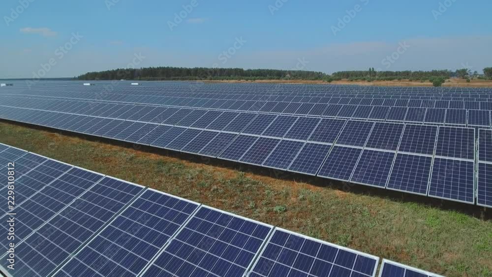 Long plate with a solar panels on meadow. Shot on drone Long plate with a solar panels on meadow. Shot on drone