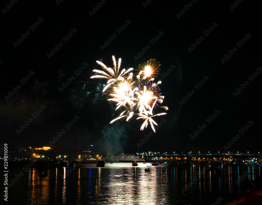 Fototapeta premium Salute of blue yellow white green fire splashes against the night Kostroma