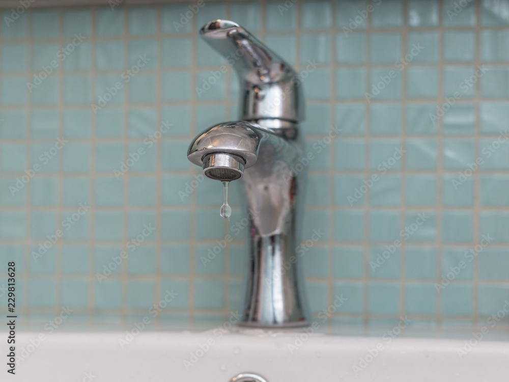 drops falling from the faucet in the bathroom drops falling from the faucet in the bathroom