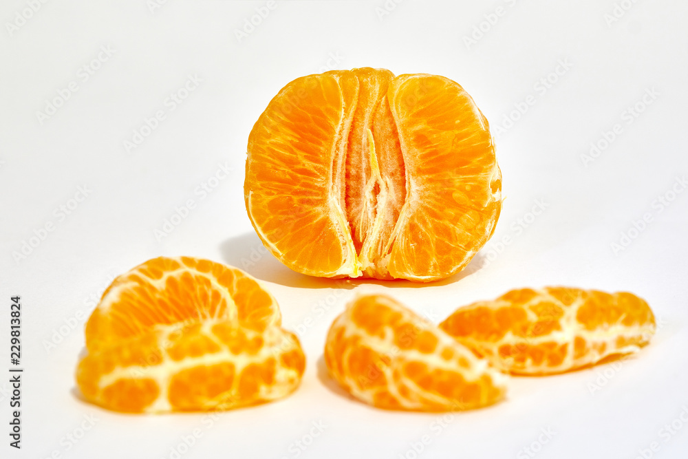 A peeled tangerine photographed in studio isolated in macro with a white background A peeled tangerine photographed in studio isolated in macro with a white background
