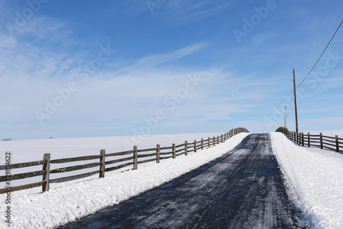 Road thru the Country in Winter after Snowfall - road bordered by wooden fence © junej