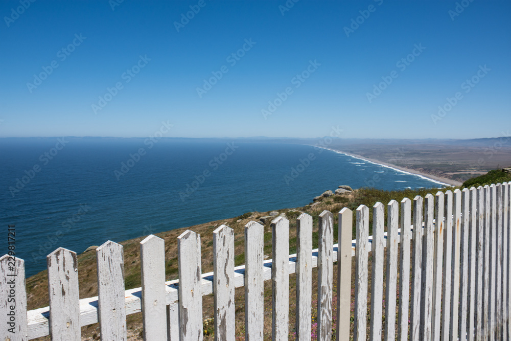 White picket fence and the Point Reyes National Seashore shoreline of Marin County California