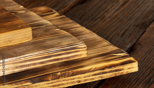 selective focus of stack of different wooden cutting boards on wooden table