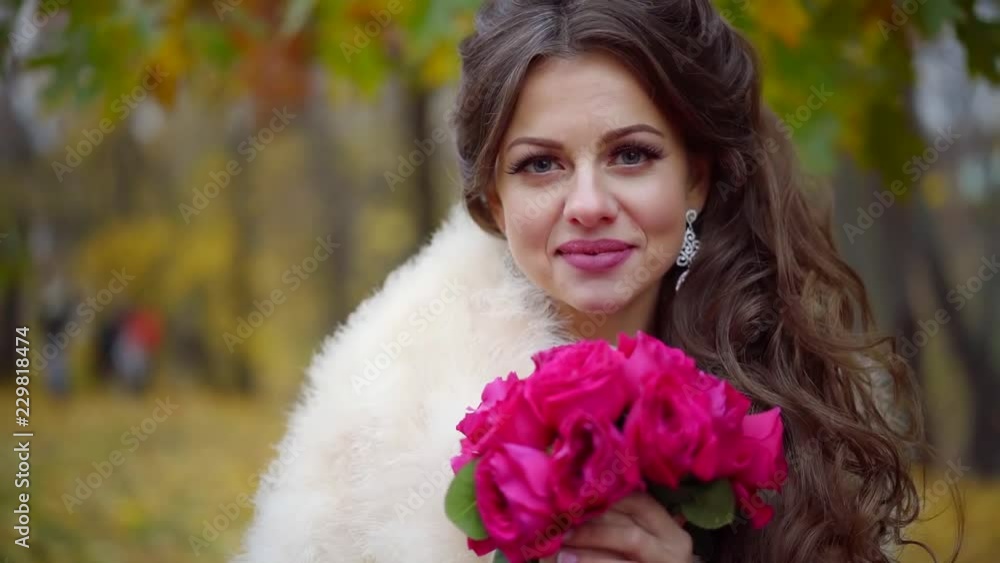 Portrait of a pretty young bride in a wedding dress and veil with a bouquet of beautiful flowers in the autumn Park Portrait of a pretty young bride in a wedding dress and veil with a bouquet of beautiful flowers in the autumn Park