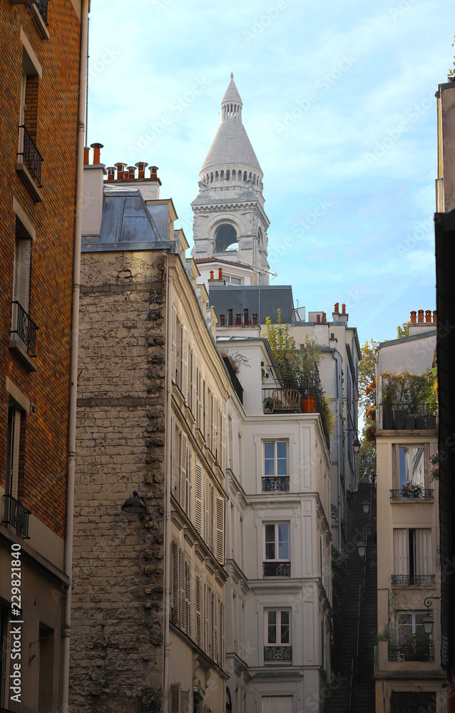Typical parisian houses of Montmartre and Basilica of Sacre Coeur on background, Paris, France