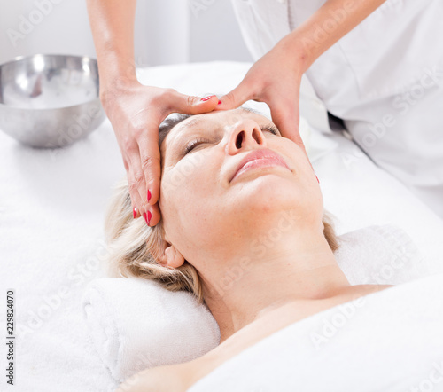 Mature woman having face massage