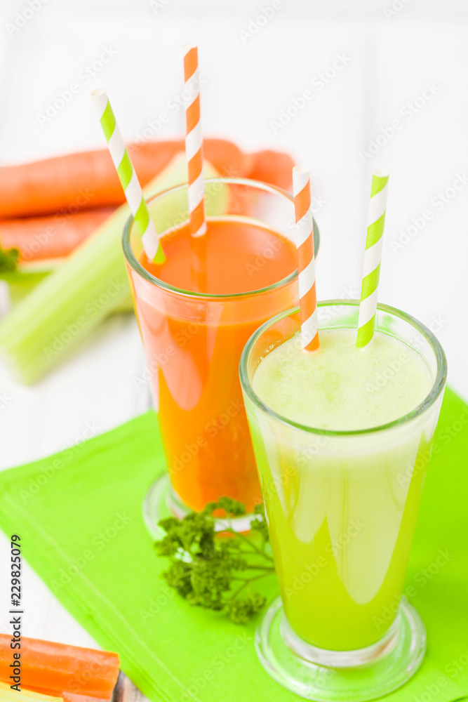Carrot and celery juice with fresh vegetables on bark plates on wooden background. Carrot and celery juice with fresh vegetables on bark plates on wooden background.