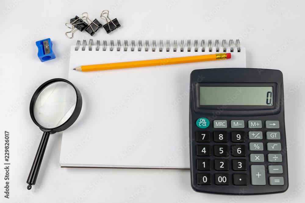 Notebook for taking notes and pencil on the office table. Accessories for quotation and memorization needed in accounting. Notebook for taking notes and pencil on the office table. Accessories for quotation and memorization needed in accounting.