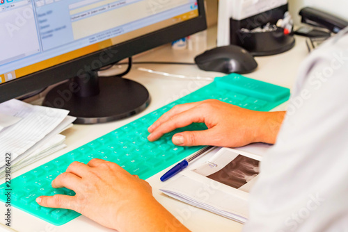 Female hands type on blue silicon keyboard close