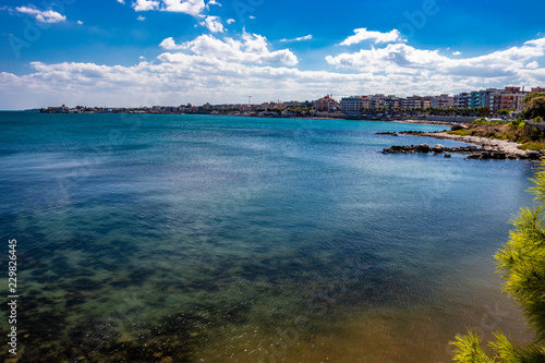 view of the sea, in the city of Trani, with the Monastery of Santa Maria di Colonna in the background. In Puglia, near Bari, Barletta, Andria. Sea and blue sky, slightly cloudy. photo