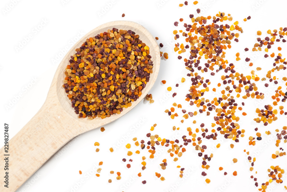 Bee pollen in the wooden spoon on white background Bee pollen in the wooden spoon on white background