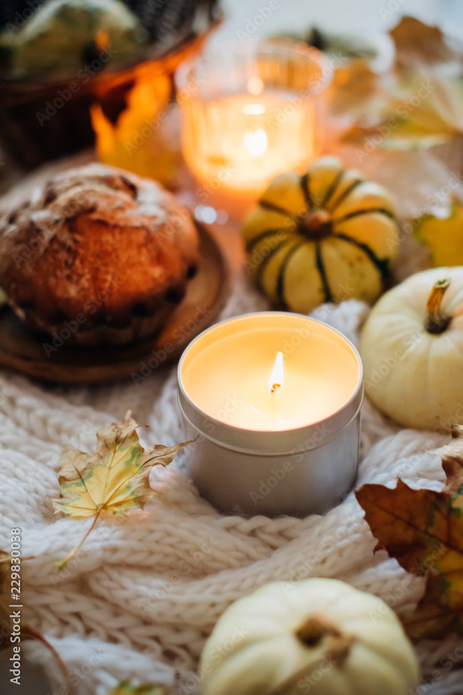 Burning candle in jar, autumn leaves and small decorative pumpki Burning candle in jar, autumn leaves and small decorative pumpki