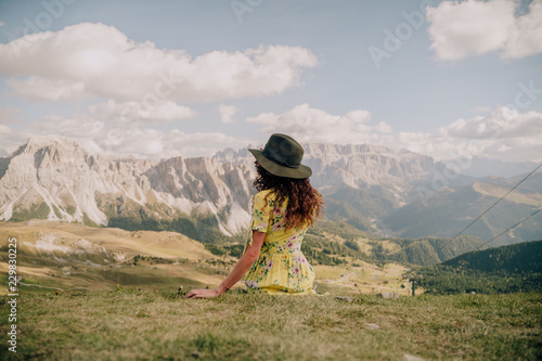 Mujer con sombrero mirando vistas de un valle de montañas