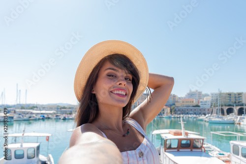 Elegant young tourist visitor woman walking on a sightseeing tour at Heraklion Venetian port, Crete, Greece  © Stockphototrends