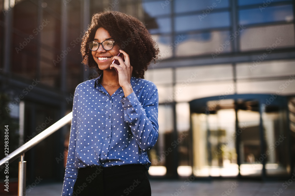 Female business professional walking outside using phone